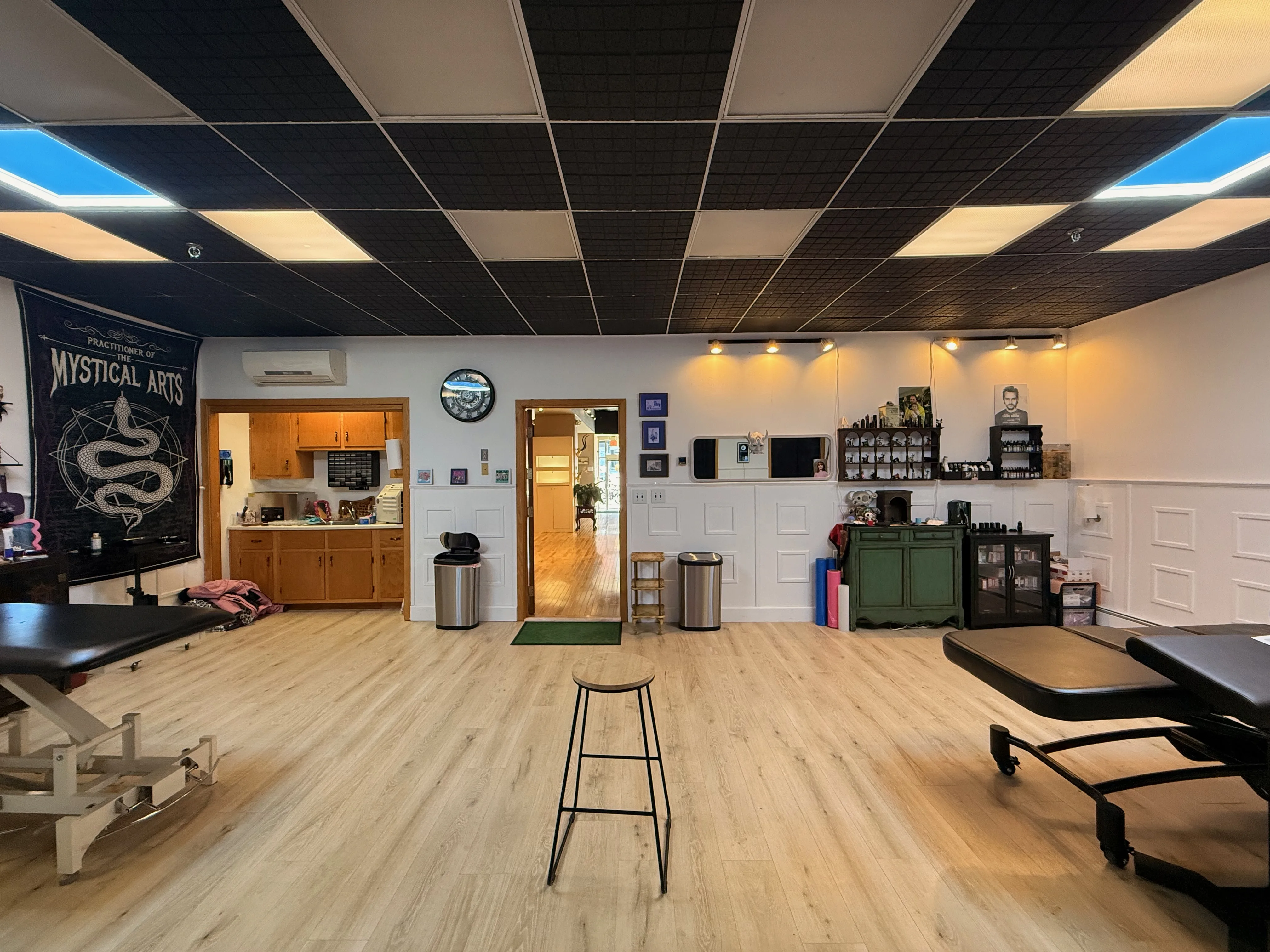 Clean tattoo workspace with open floor plan and studio television